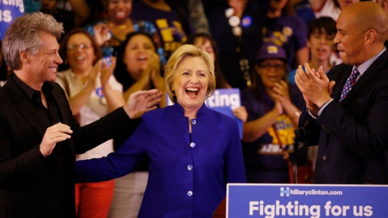 Democratic presidential candidate Hillary Clinton speaks at a campaign rally, June 1, 2016, in Newark, New Jersey. Next to Clinton is musician Jon Bon Jovi. / AFP / DOMINICK REUTER (Photo credit should read DOMINICK REUTER/AFP/Getty Images)