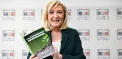 President of the French far-right party Rassemblement National (RN) and MP Marine Le Pen poses with a document during a press conference to present a counter-proposal for a referendum on ecology, ahead of a session of the National Assembly on changing the constitution to include a commitment to fight against climate change and for the protection of the environment in Paris on March 9, 2021. (Photo by Alain JOCARD / AFP)