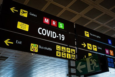 Information panel with Covid-19 word on it at an international airport