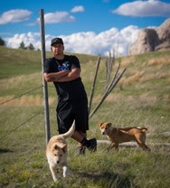 justin with dogs on prairie