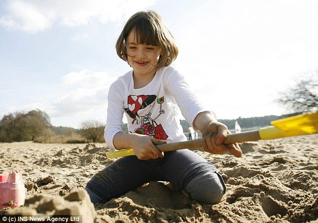 Warm weather: Lily Wilson, seven, enjoys the spring-like conditions at Frensham Pond, Frensham, Surrey today