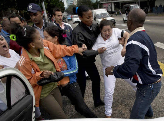 Una disidente cubana es detenida por oficiales de seguridad antes del inicio de una manifestación por el Día Internacional de los Derechos Humanos en La Habana, Cuba, el miércoles 10 de diciembre de 2014. (AP foto/Ramon Espinosa)
