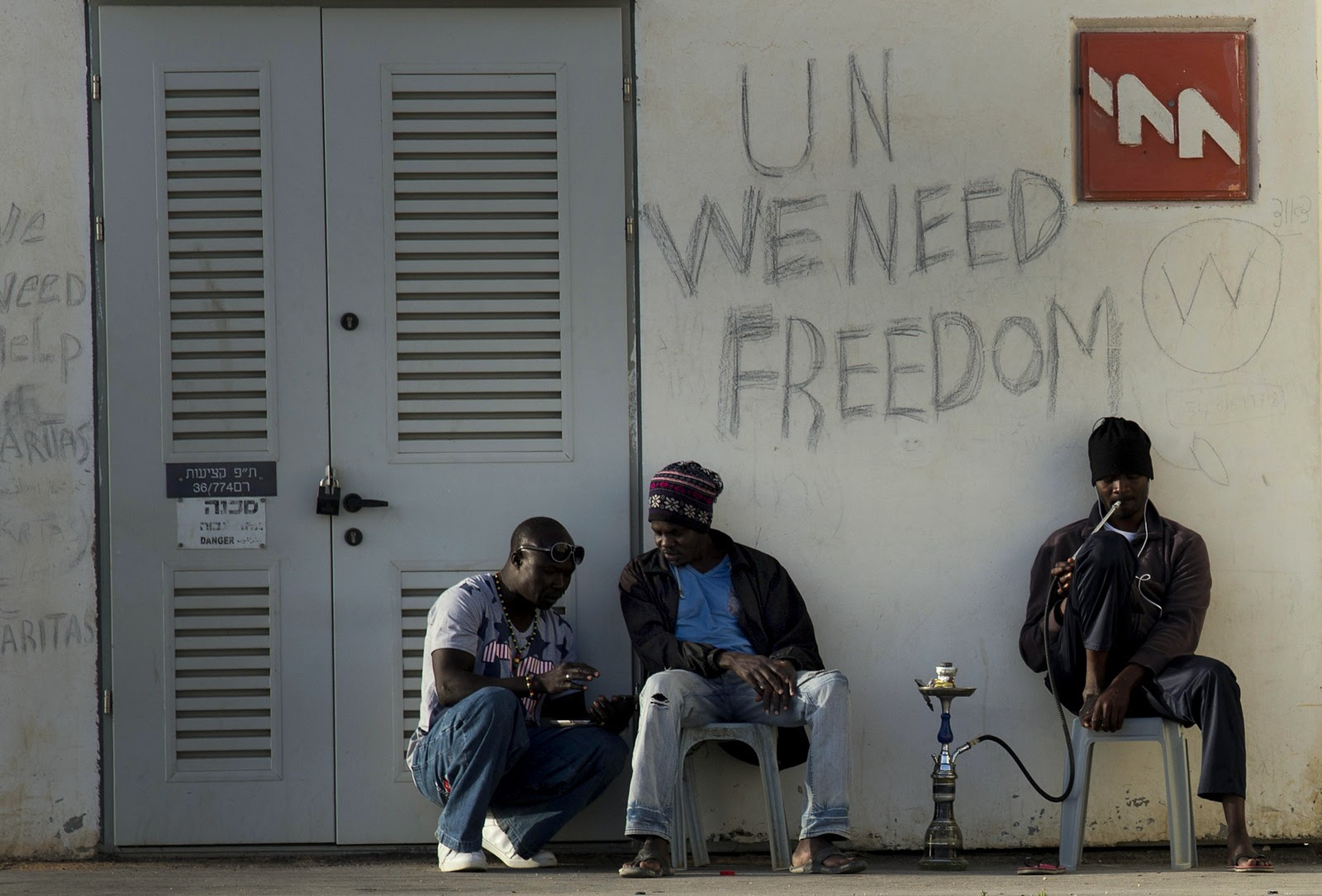 African migrants sit outside Holot detention center in the Negev Desert, southern Israel, Tuesday, April 21, 2015. Tens of thousands of African asylum seekers have made their way to Israel in recent years. Most of them came from Eritrea, an eastern African nation with one of the worldâ€™s most dismal human rights records. (AP Photo/Tsafrir Abayov)