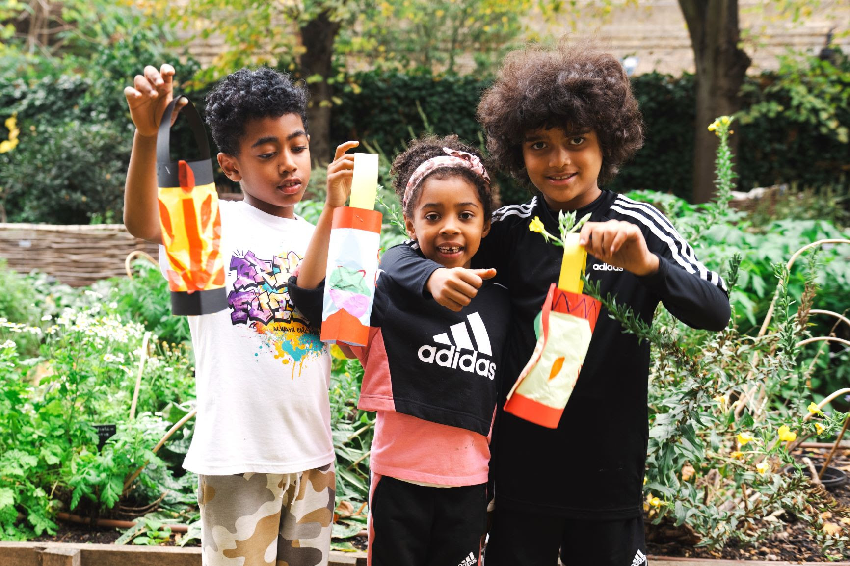 Three children holding hand made paper Diya lamps