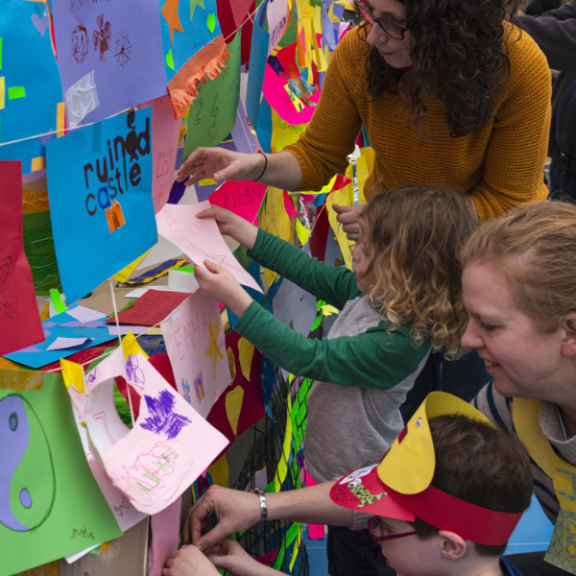 Children and women attaching colorful cards to the wall