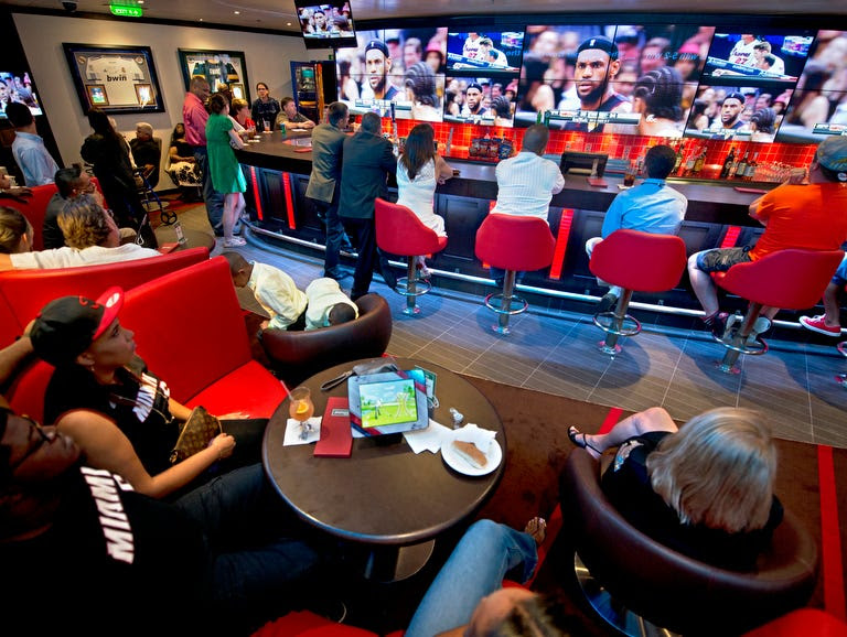 Guests aboard the Carnival Freedom watch the NBA Finals in the ship's EA Sports Bar.