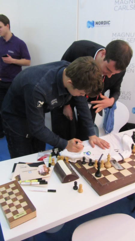 Magnus Carlsen firmando un polo del Club Reverté