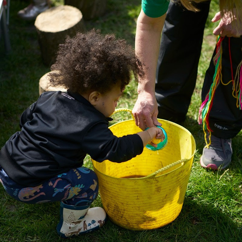 A young child taking part in Outdoor Messy Play