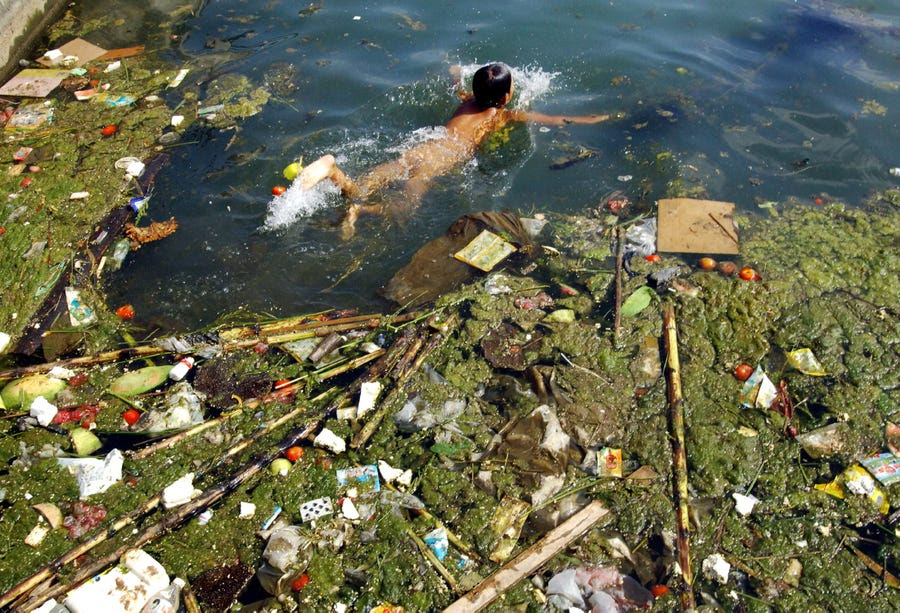 A child swims in a polluted reservoir, southwest of China's Guizhou province, in September 2006. 