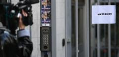 A press reporter films the entrance of French leftist movement La France Insoumise's (LFI) headquarters where is taped a sheet of paper reading "Matignon" (French Prime minister's residence) in Paris on April 27, 2022 before a meeting with French socialist party (PS) representatives to discuss a possible electoral agreement between the two parties for the June 2022 parliamentary elections in France. (Photo by Christophe ARCHAMBAULT / AFP)