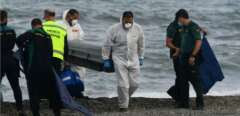 Des employés des pompes funèbres portent le corps d'un migrant sur la plage de l'enclave espagnole de Ceuta, le 20 mai 2021.