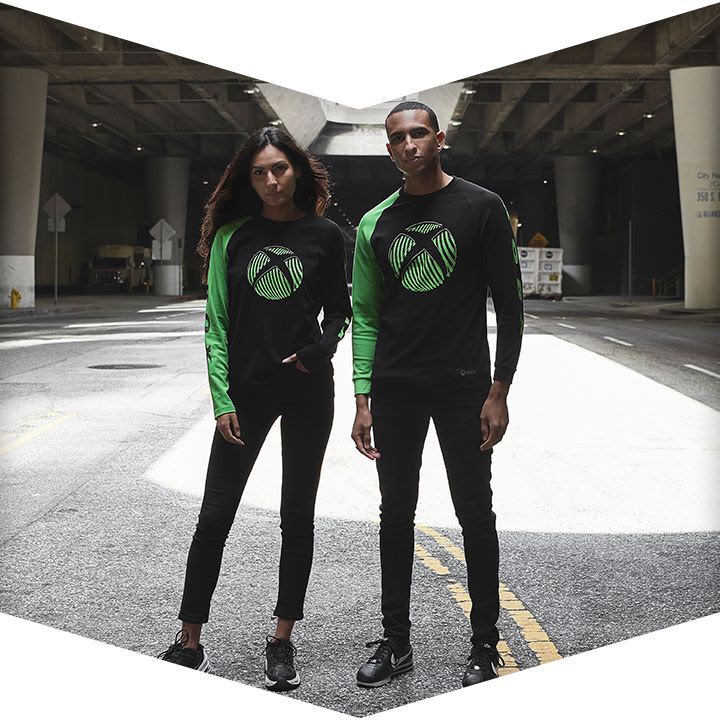 Two models show off official Xbox gear beneath a freeway overpass.