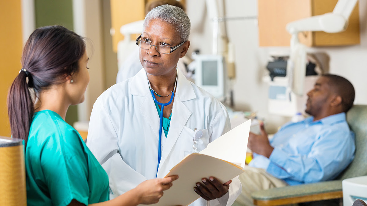 Nurse and doctor discuss health information related to a patient 