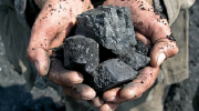 Close-up shot of a mineworker holding coal.