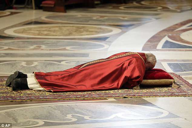 Pope Francis lies down in prayer during the Good Friday Passion of Christ Mass, inside St. Peter's Basilica, at the Vatican earlier on Friday