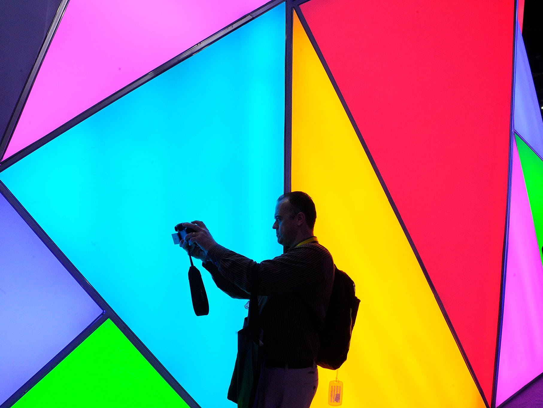 1/6/2015 -- Las Vegas, NV, U.S.A  -- CES 2015.  Terry Sullivan is silhouetted as he takes a selfie against a colorful set of lights at the TCL booth at CES.    Photo by Tim Loehrke, USA TODAY staff ORG XMIT:  TL 132324 mark fields ford 1/5/2015 [Via 