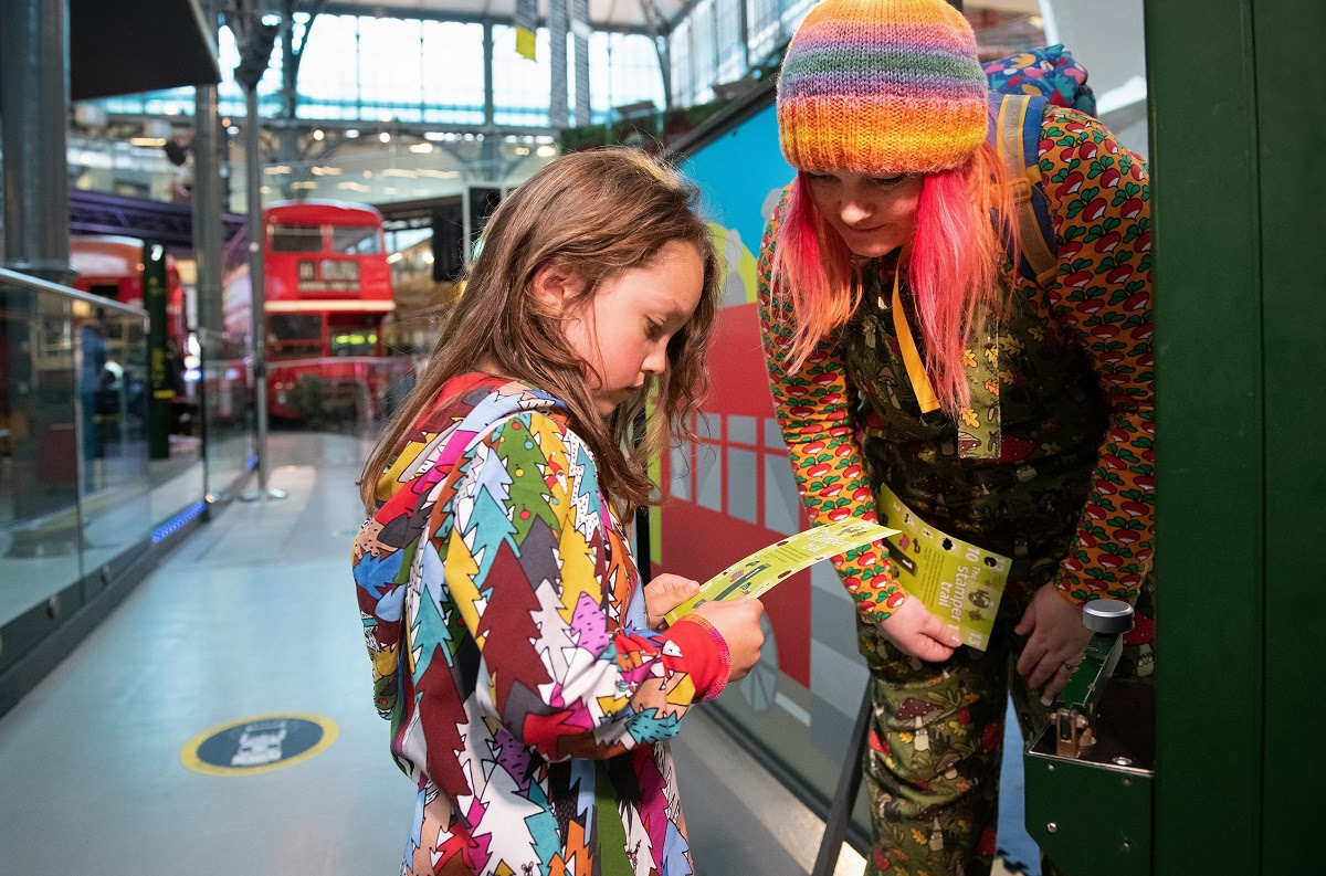 A woman and a girl following a trail in a museum