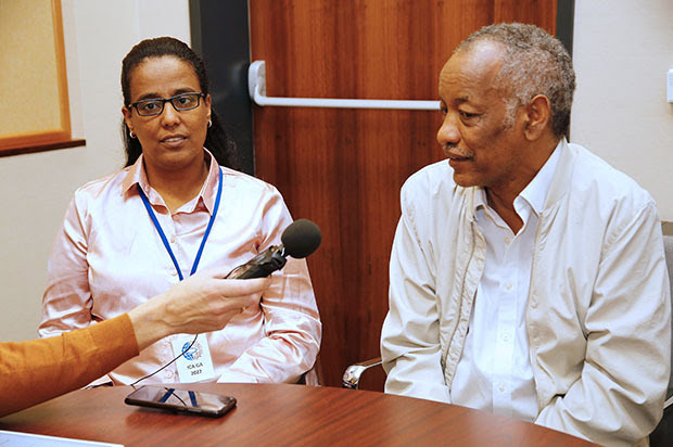 Woman and man talking into microphone