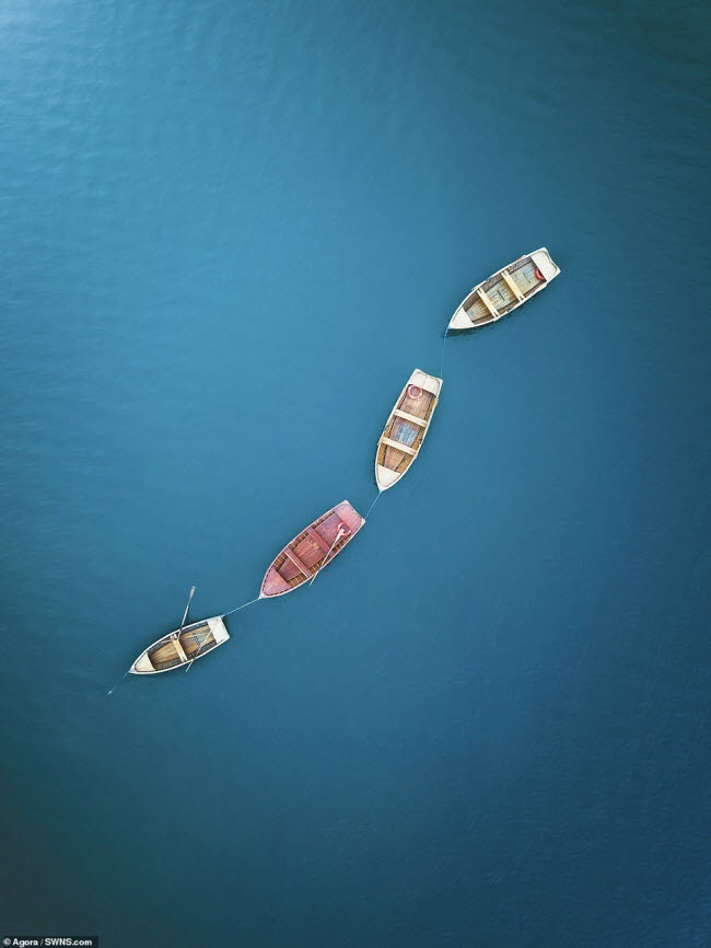 Những chiếc thuyền đậu trên mặt nước phẳng lặng ở Italia.