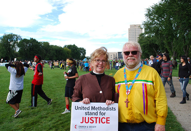 Susan Henry-Crowe, top executive of the United Methodist Board of Church and Society, and Fr. John Floberg, rector of Episcopal churches St James, St. Luke's and Church of the Cross on the Standing Rock nation, stand outside the North Dakota state capitol grounds in Bismark in 2016. Henry-Crowe retired on Dec. 31, 2022, after eight years leading Church and Society and almost 49 years of active ministry in The United Methodist Church. File photo by John Hill, Church and Society.