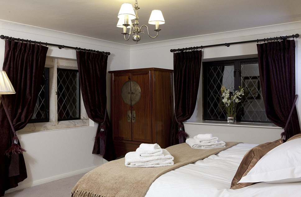 With purple curtains and a period piece wardrobe in the corner the main bedroom at Bath Lodge Castle looks fit for royalty