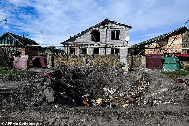 A photo shows damaged houses and a crater in the ground in Siversk, Donetsk region