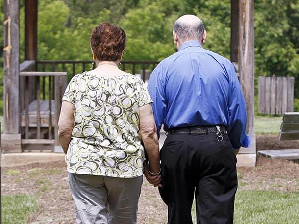 middle aged couple walking hand in hand in the park