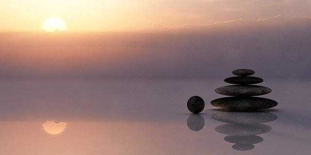 Photo of a pile of pebbles against a soft sunset.