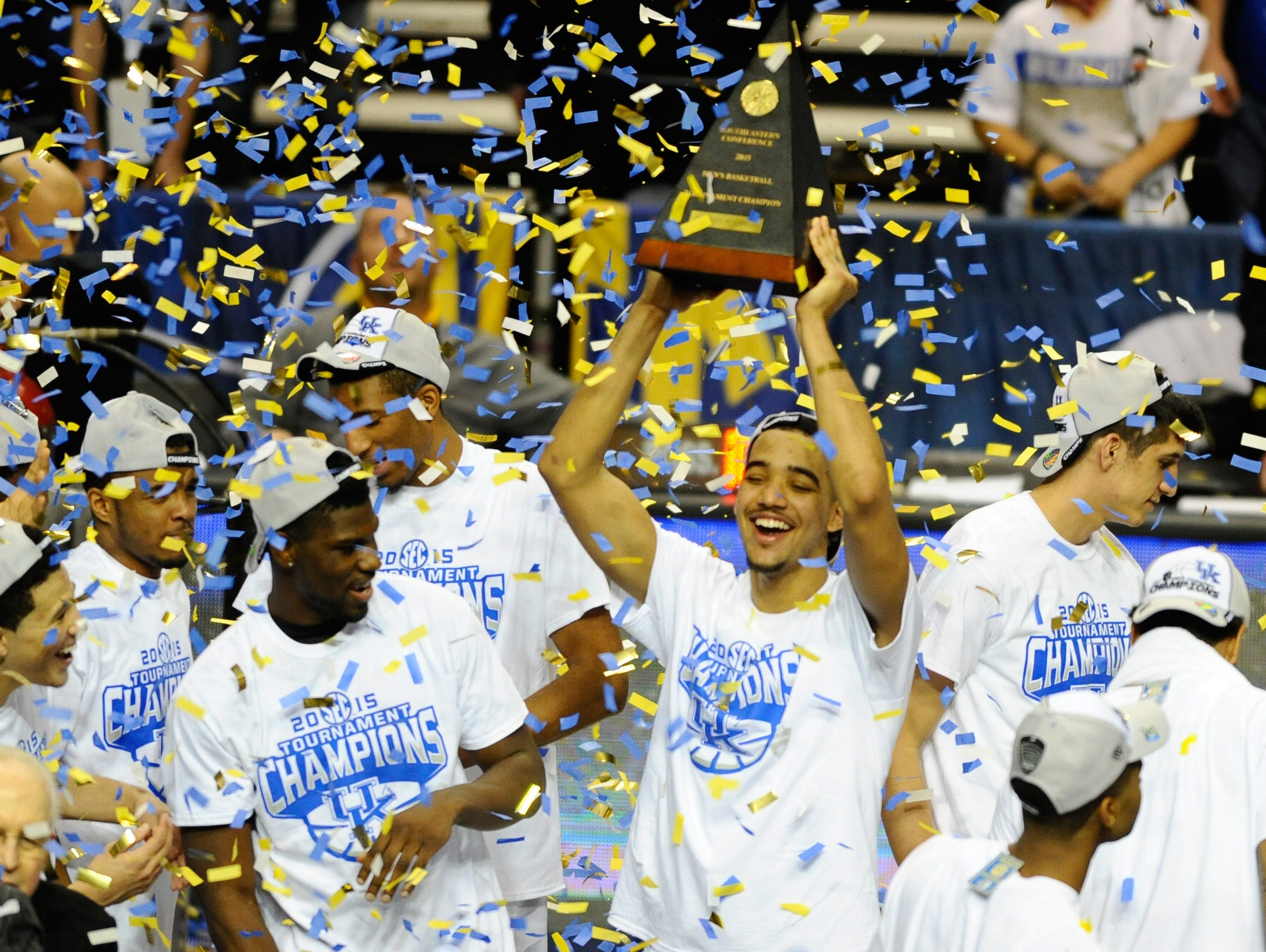 Kentucky players celebrate with the championship trophy after winning the SEC Conference Championship game against Arkansas.