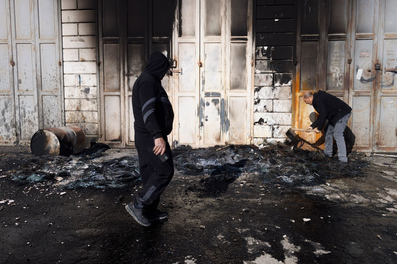 Palestinians clean a burned shop a day after the clashes between Jewish settlers and Palestinians in Huwara, West Bank, on Monday. (Kobi Wolf for The Washington Post/FTWP)