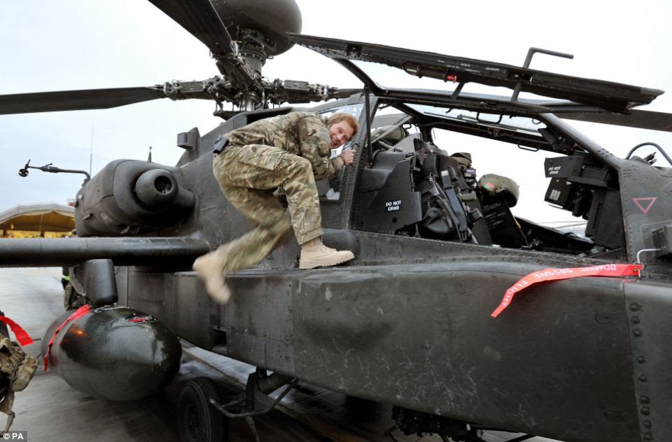 Prince Harry appears to be sharing a joke with photographers as he gets into his Apache helicopter during early morning pre-flight checks