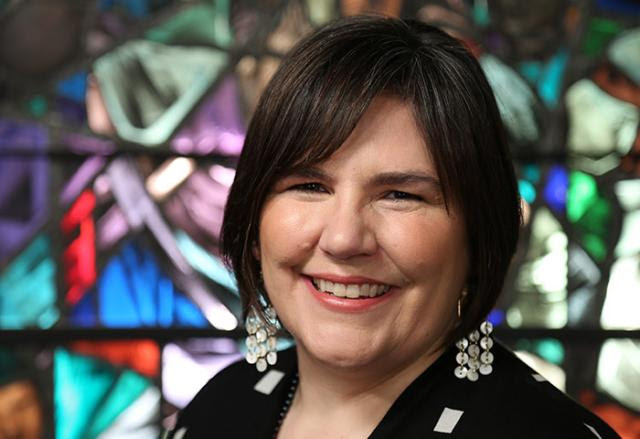 Moderator Carmen Lansdowne in front of stained glass