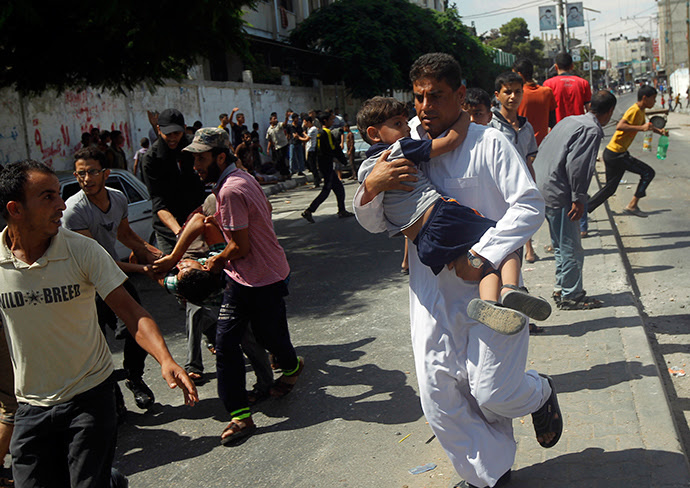 Palestinians carry injured people following an Israeli military strike on a UN school in Rafah, in the southern Gaza Strip on August 3, 2014 (AFP Photo / Said Khatib)