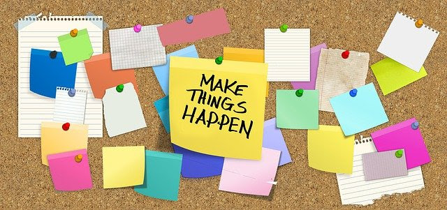 Corkboard with post it that reads "Make things happen"