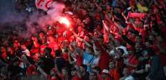 A liverpool supporter holds a flare in the stands during the UEFA Champions League final football match between Liverpool and Real Madrid at the Stade de France in Saint-Denis, north of Paris, on May 28, 2022. (Photo by FRANCK FIFE / AFP)