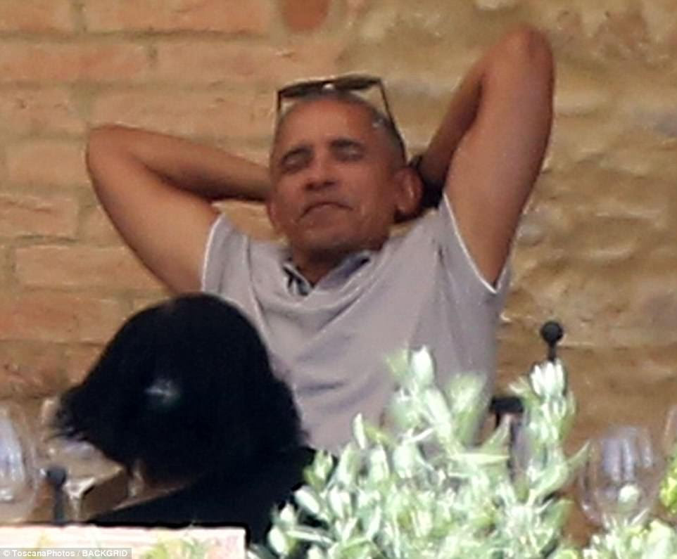 Happy as can be: The former president wore his sunglasses on top of his head during the meal, and at one point he leaned back and placed his hands behind his head to stretch