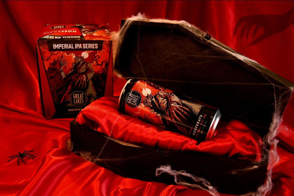 Can of Nosferatu resting in an open coffin, with a shadowy hand reaching for the can.