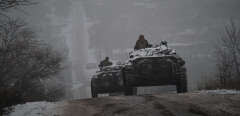 Ukrainian servicemen ride atop BMP-2 infantry combat vehicles driving down an icy road in the Donetsk region on January 30, 2023, amid the Russian invasion of Ukraine. (Photo by YASUYOSHI CHIBA / AFP)