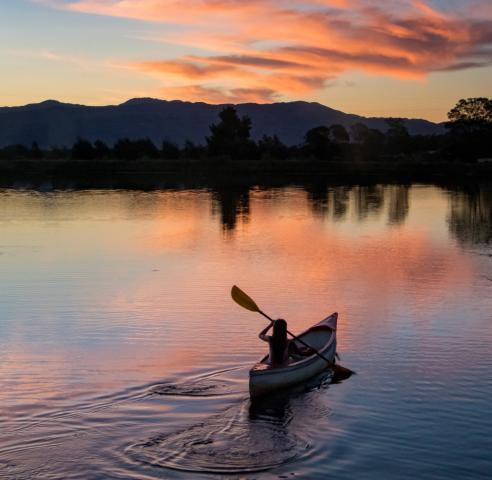 Person Canoeing during  a pink sunset