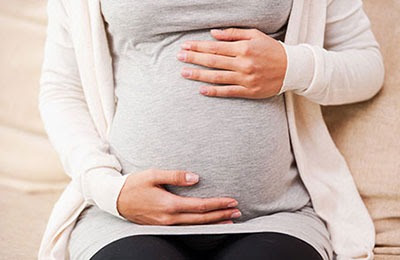 Pregnant woman with hands on stomach