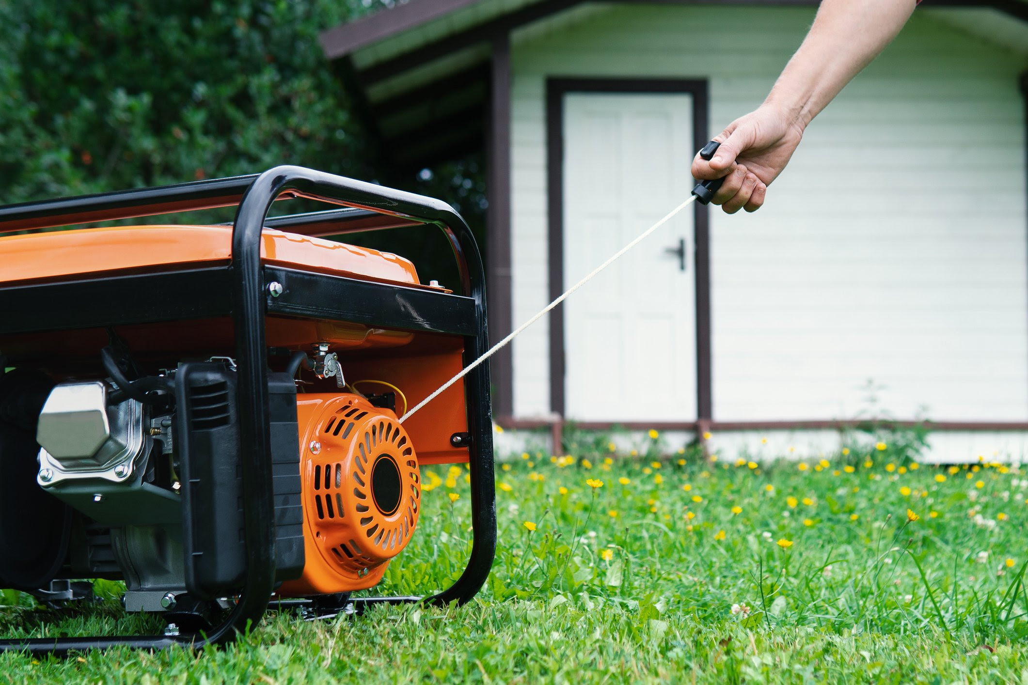 A person starts a generator after losing power in their home.