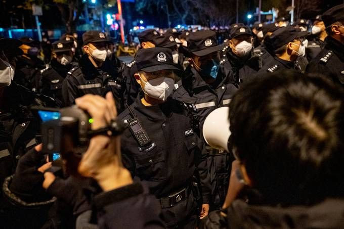 Police officers stand guard during a protest in Beijing on Nov. 28. (Bloomberg)