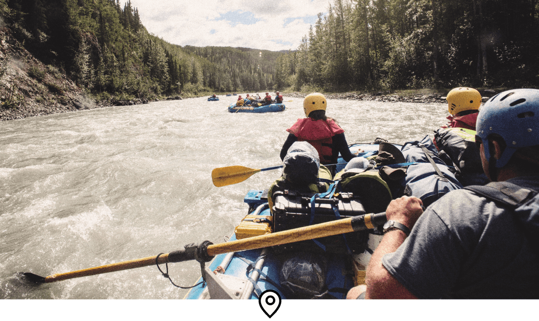 Descrição da imagem: Vista traseira de um grupo de viajantes praticando rafting no Wells Gray Park, Canadá