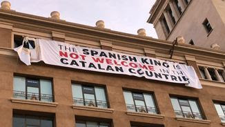 La pancarta penjada en un edifici de la plaça de Catalunya de Barcelona diu, en anglès: "El rei espanyol no és benvingut als Països Catalans"