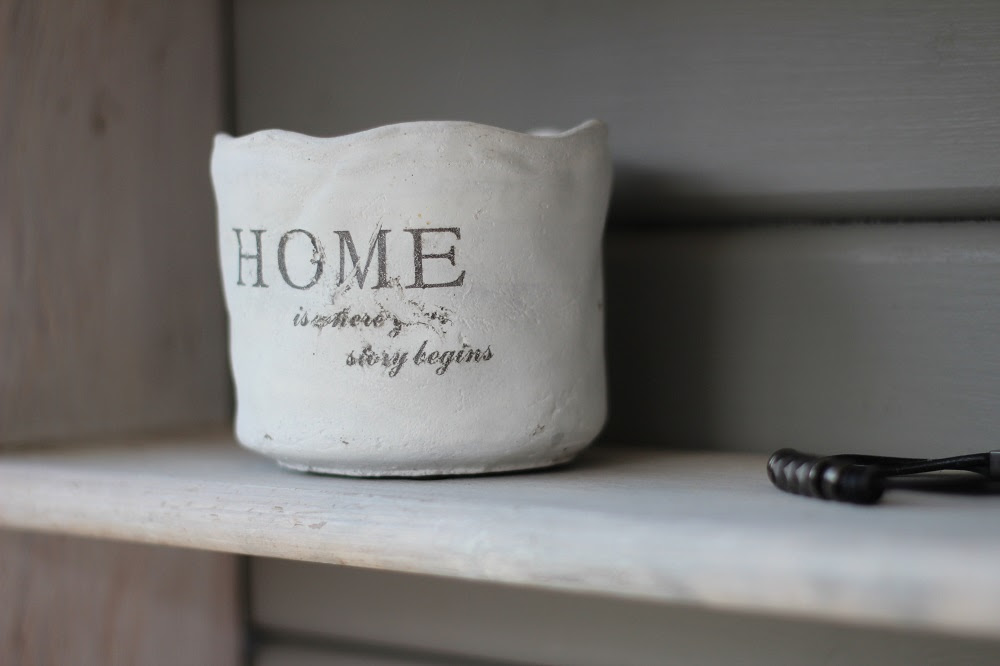 Photo of a ceramic pot with the words "Home is where your story begins" on it.