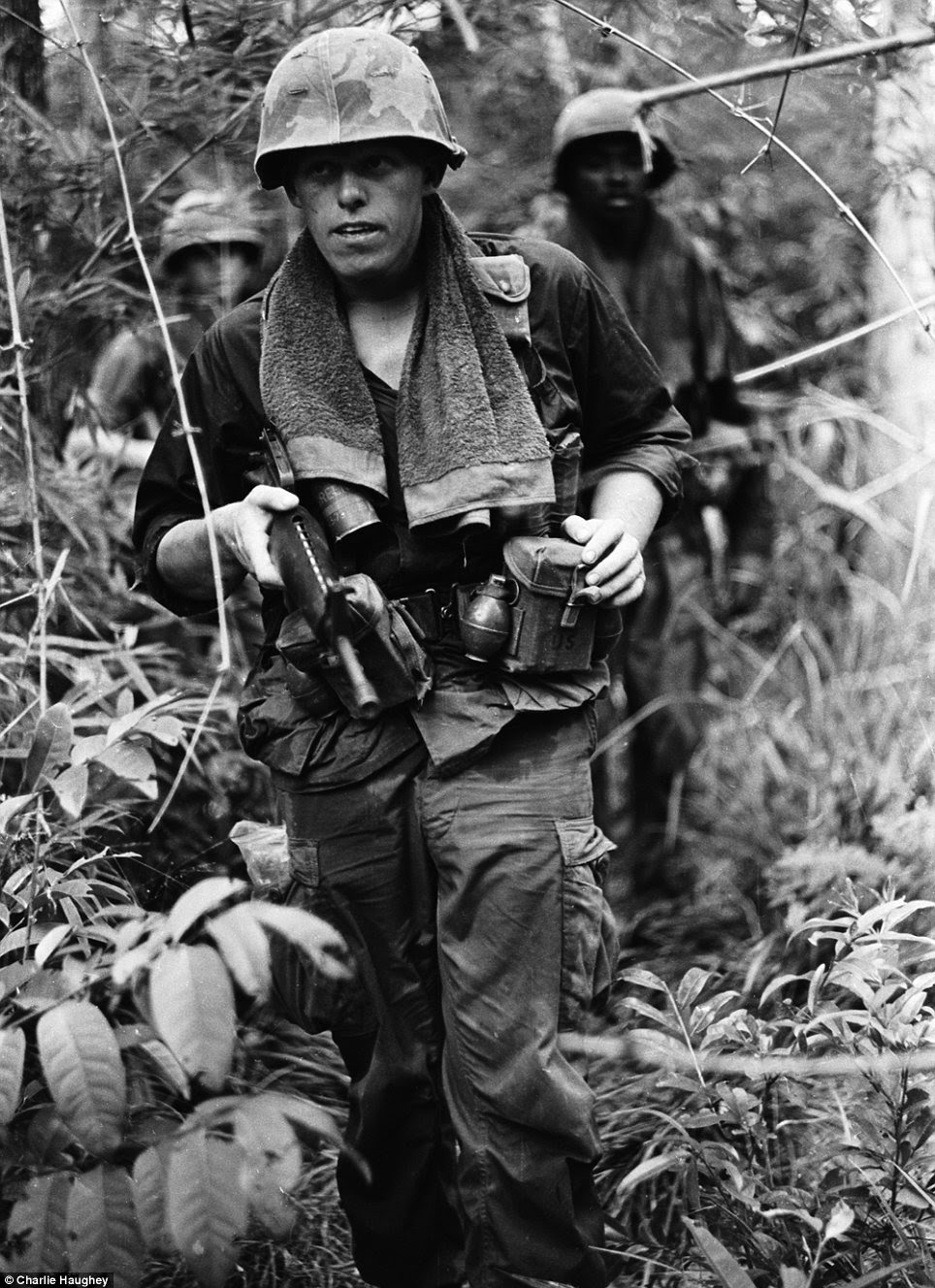 Tough: Soldiers wore towels around their necks to wipe away sweat in the relentless jungle heat