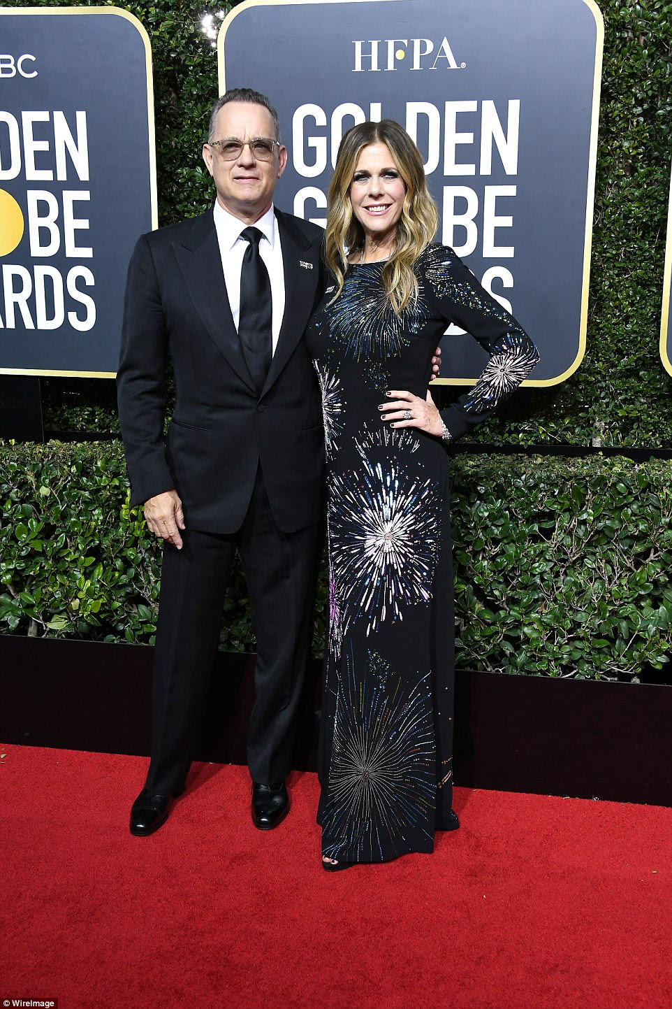 Então, apaixonado: Tom Hanks pareceu bem em seu terno enquanto sua encantadora esposa, Rita Wilson, escolheu um número inspirado no fogo-de-artifício