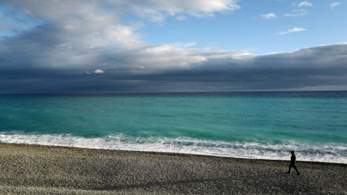 Un homme se promène sur la plage de Nice