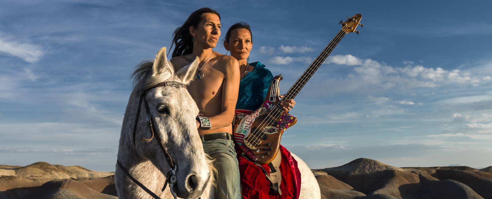 Sihasin, a dupla de irmãos Jeneda e Clayson Benally a cavalo com um violão.