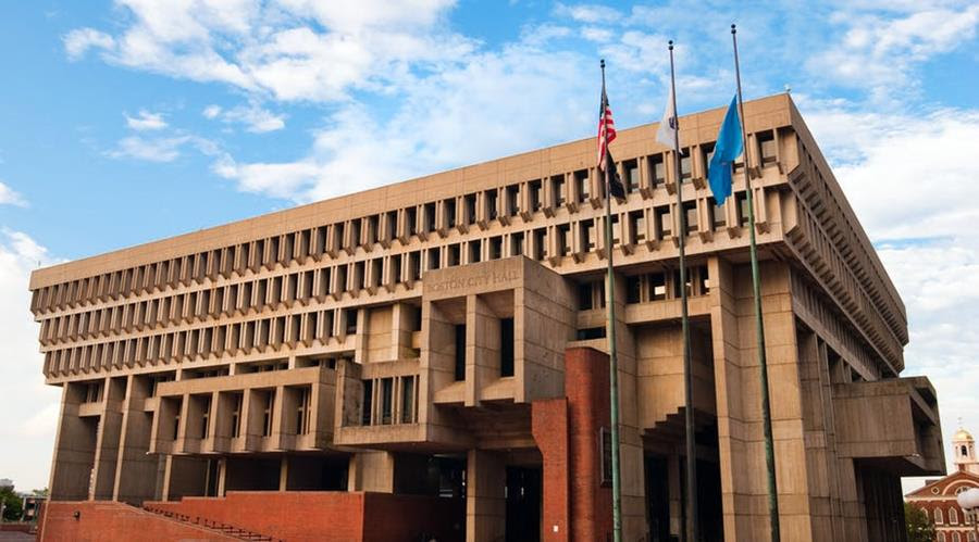 Three flags stand in front of Boston City Hall.